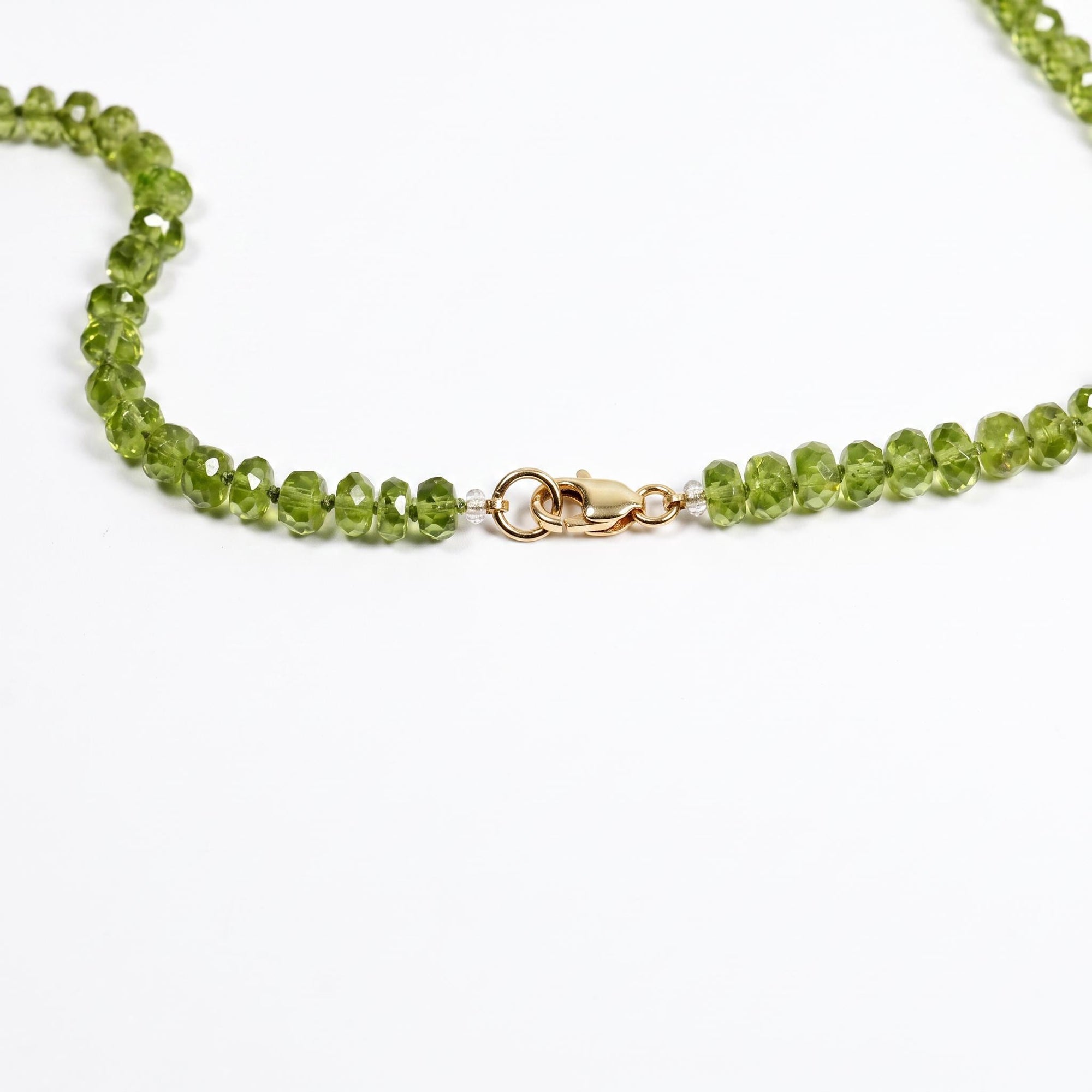Close up of 4mm peridot rondelle August birthstone beads and silk hand knotting detail with gold filled lobster clasp.