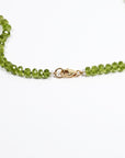 Close up of 4mm peridot rondelle August birthstone beads and silk hand knotting detail with gold filled lobster clasp.