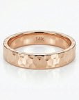 A rose gold hammered band ring with "14K" engraved on the inside.