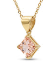 A gold chain necklace with a square, blush-pink gemstone pendant, set in a gold bezel, hangs against a white background.