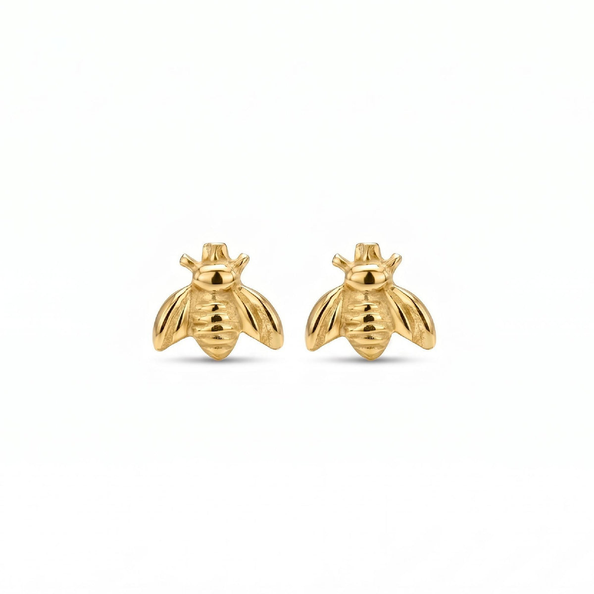 A pair of gold bee stud earrings with smooth, rounded bodies and wings are centered on a plain white background.