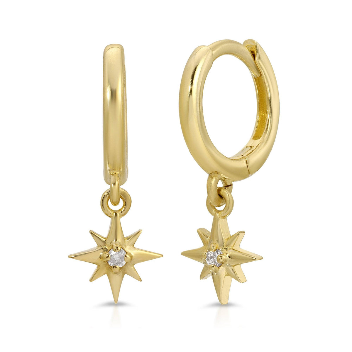 A pair of gold huggie hoop earrings featuring dangling north star charms set with small diamonds, displayed against a white background.