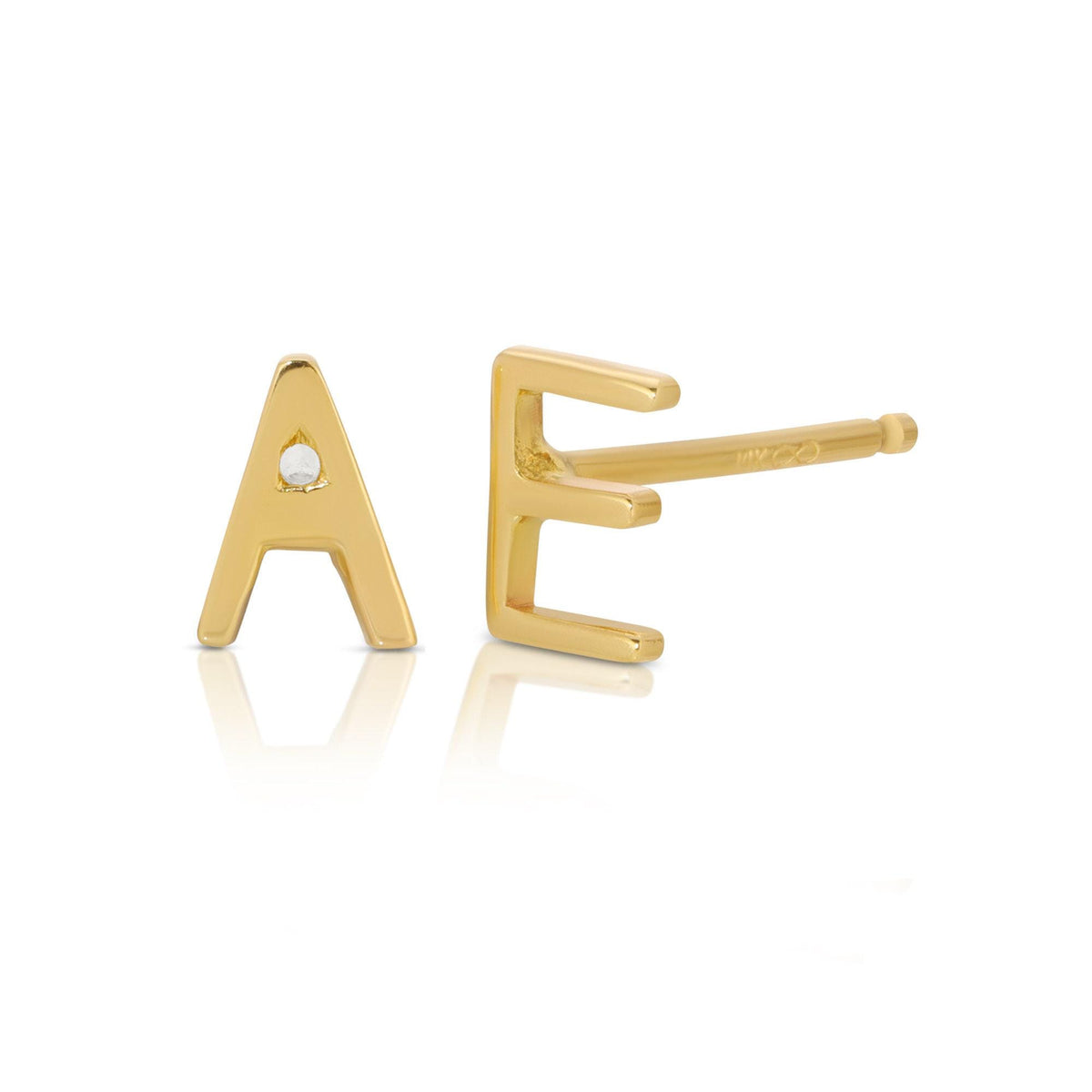 Two gold initial stud earrings shaped like the letters A and E, with the E viewed in profile showing its post.