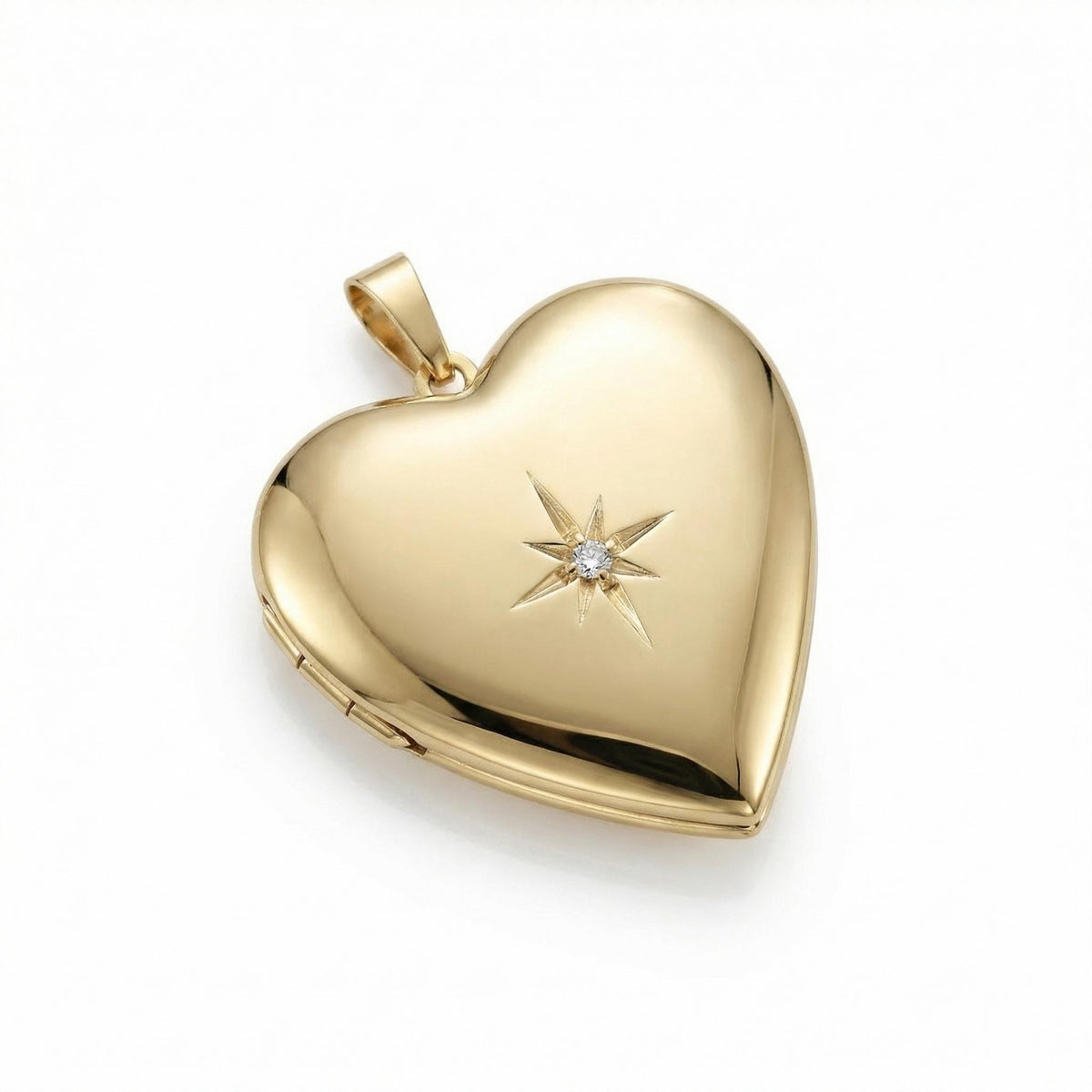 A smooth gold heart locket pendant with an engraved starburst holding a central gemstone on a white background.