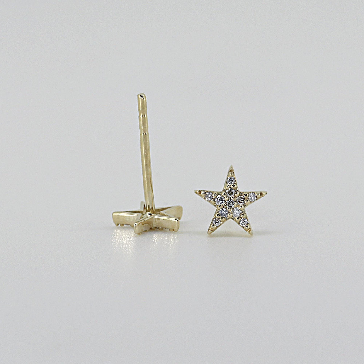 Front and back views of a single star-shaped stud earring with paved stones and a thin post.