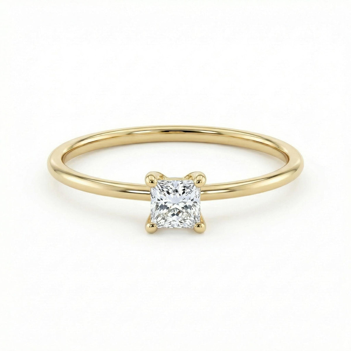 A thin gold ring featuring a single square princess-cut diamond centered in a four-prong setting against a white background.
