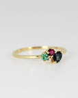 Three-quarter perspective of the gold multi-stone ring against a solid neutral white background.