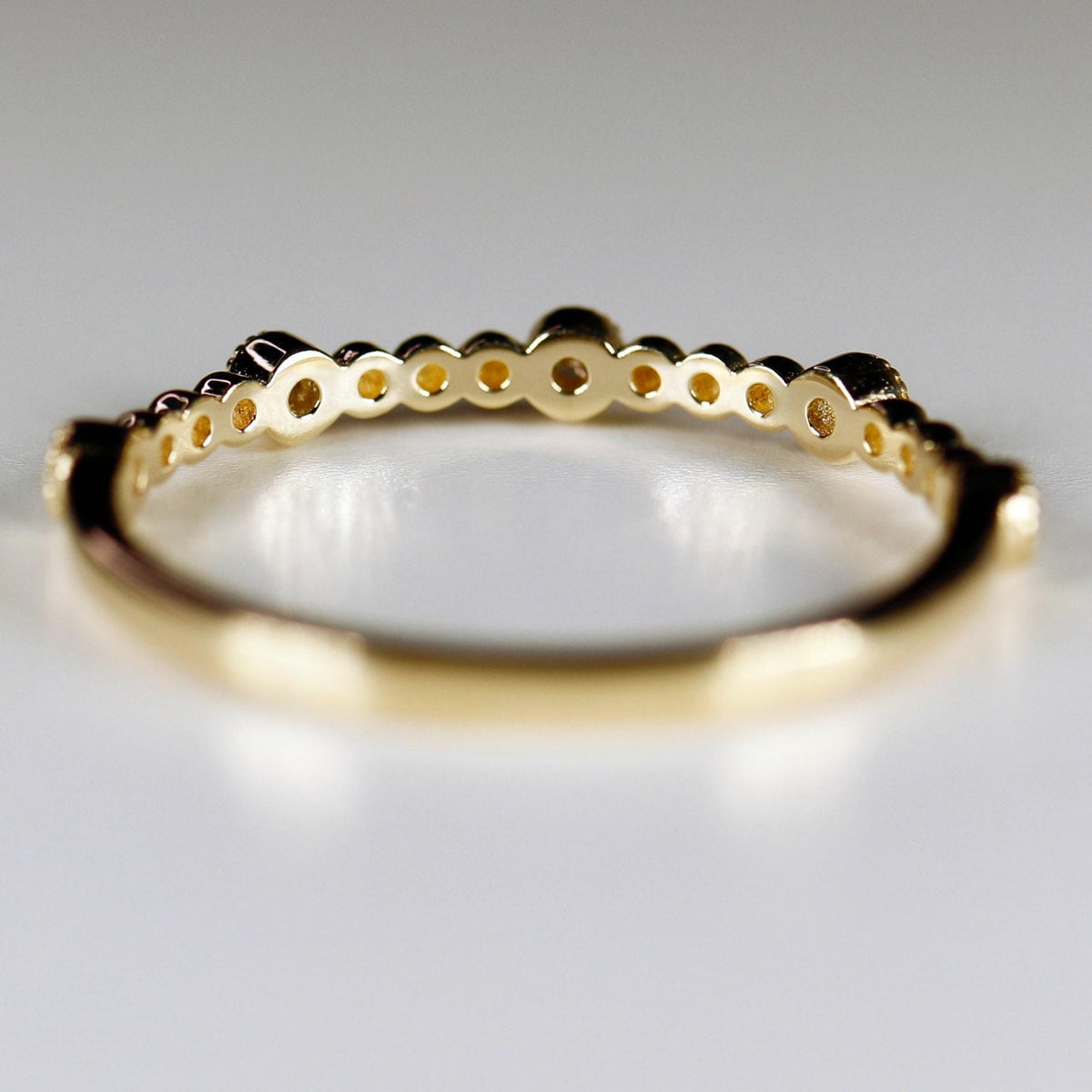 Close-up of the interior structure of a gold ring showing hollowed backing behind the stones.