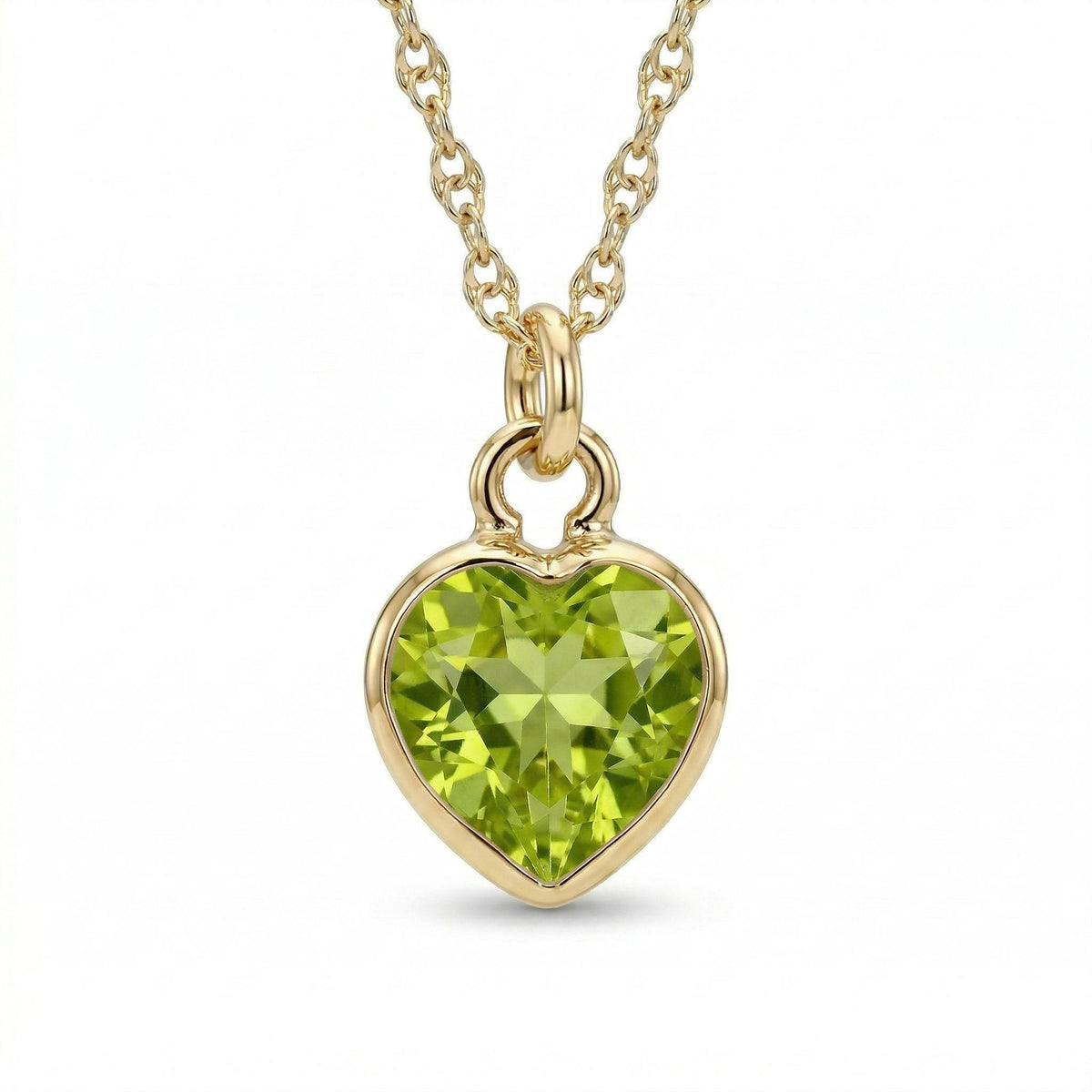 A gold necklace features a faceted heart-shaped light green gemstone pendant centered against a white surface.