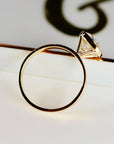 Angle view of the gold bezel-set cushion cut ring showing the inside of the circular band.