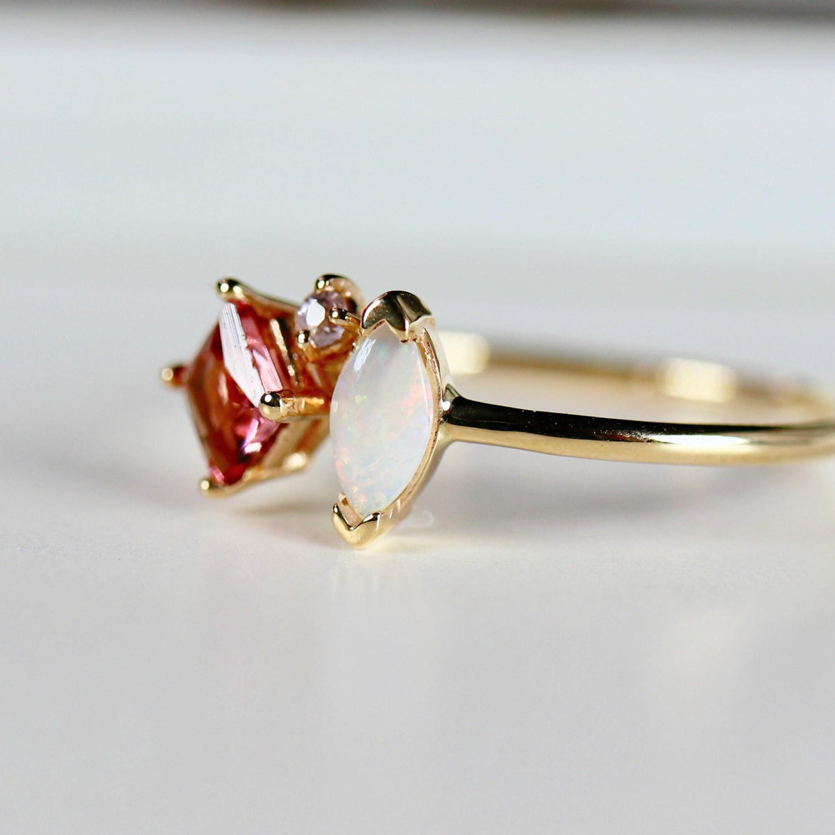 Detailed close-up of the gold ring, highlighting the iridescent marquise opal.