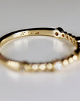 Close-up of the underside of a gold ring resting on a white surface, showing the 14k stamp inside the band.