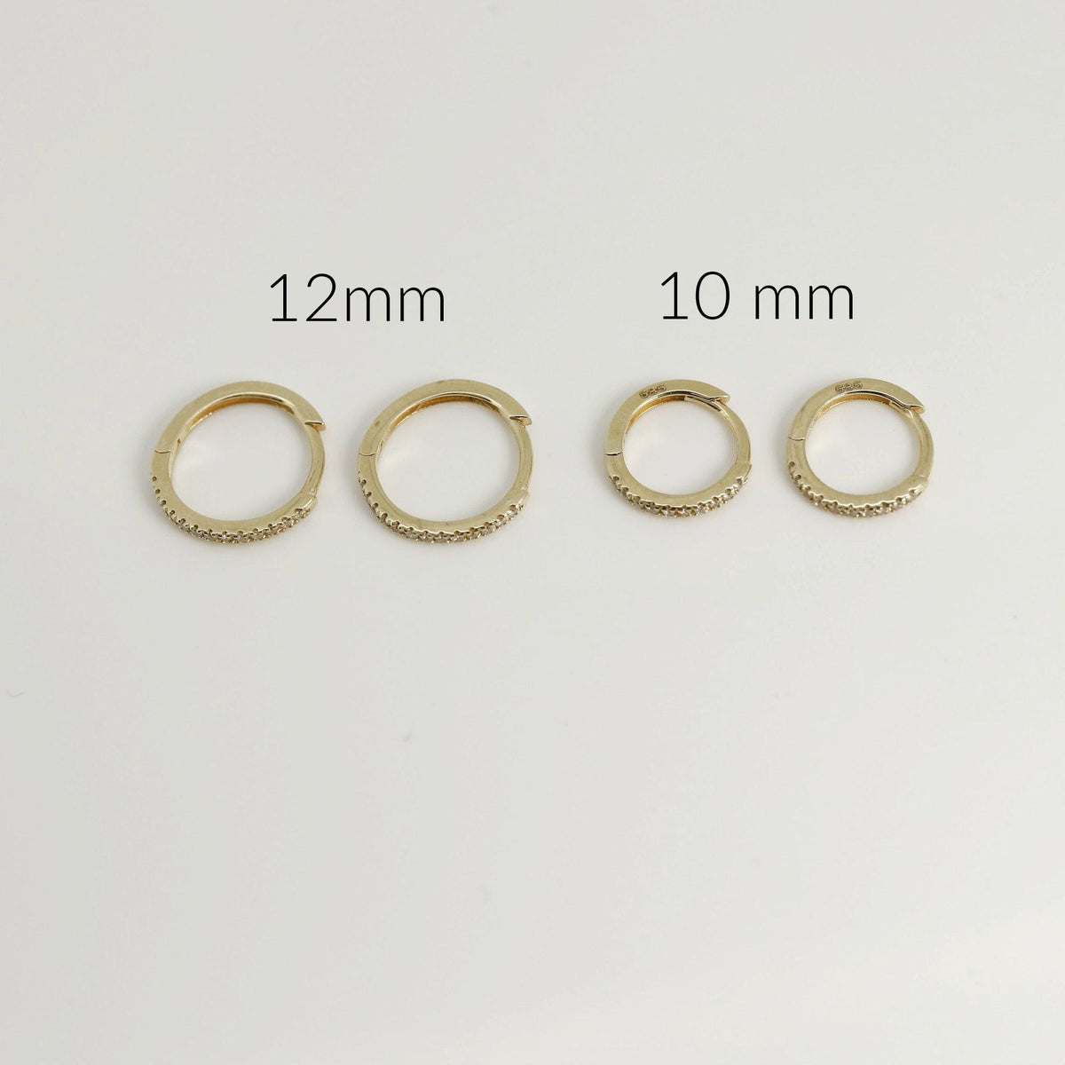 Four gold pave diamond hoop earrings displayed on a white surface, labeled with sizes 12mm and 10mm.