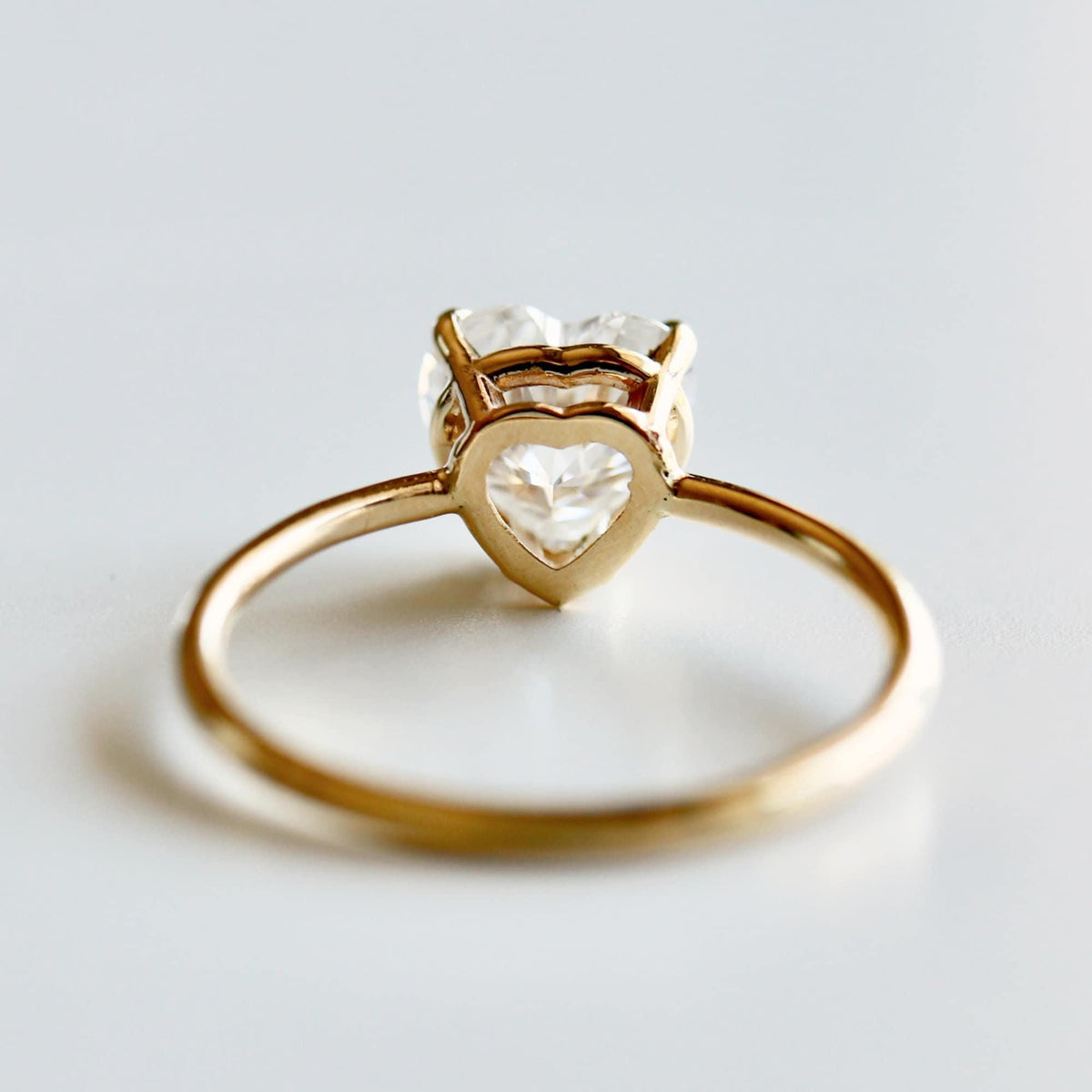 Back view of the gold ring showcasing the heart-shaped gallery wire beneath the gemstone.