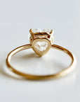 Back view of the gold ring showcasing the heart-shaped gallery wire beneath the gemstone.