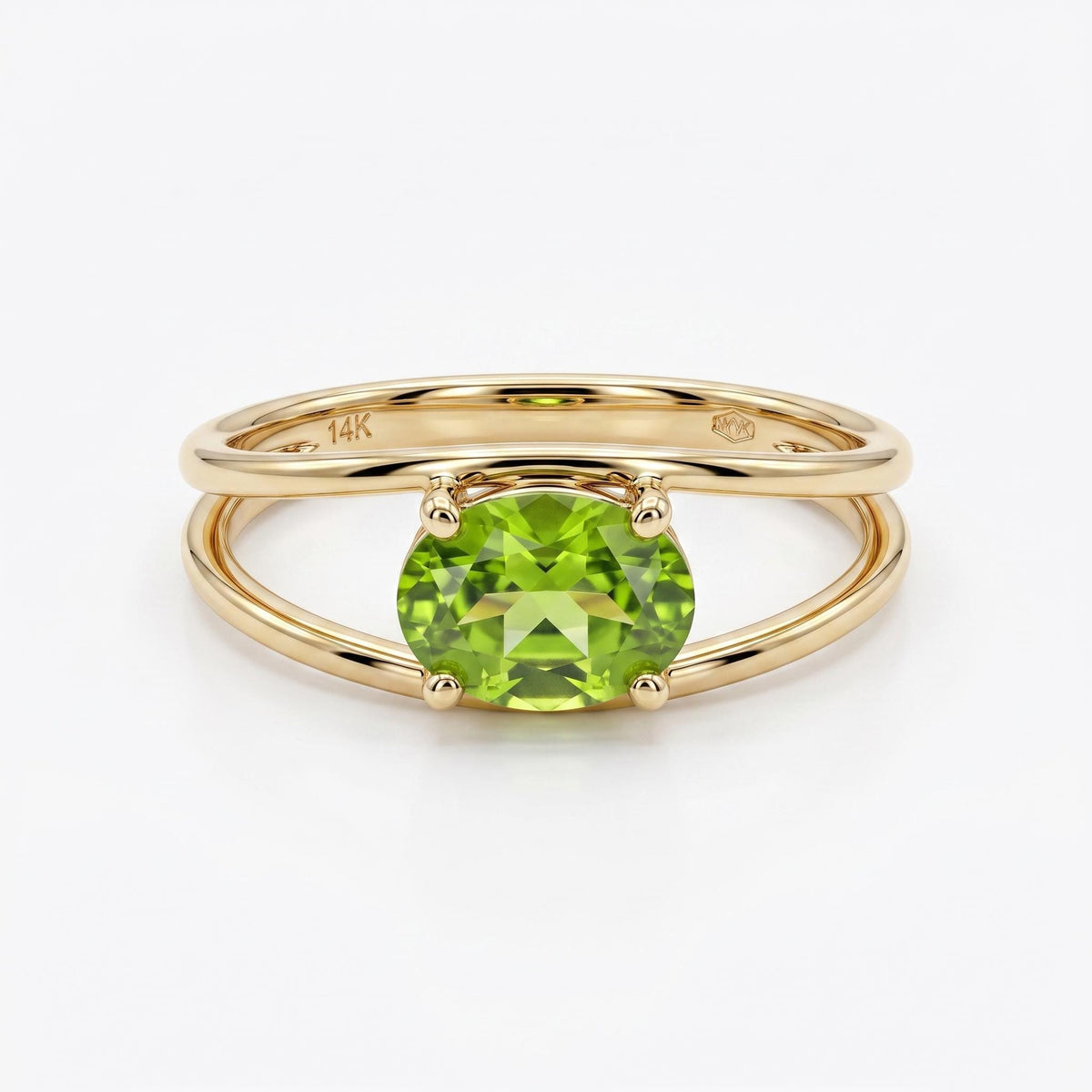 A gold double-band ring featuring a prong-set oval green peridot stone, shown centered on a white background.
