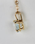 A close-up side view shows the prong setting of the heart-shaped pendant attached to a gold chain.