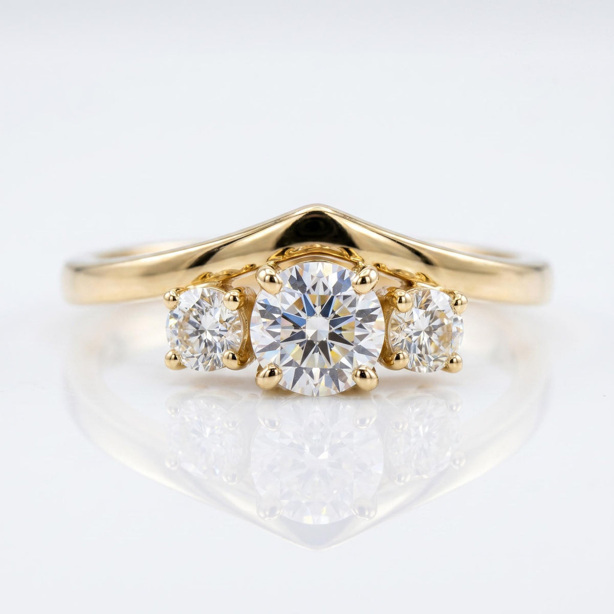 Front view of the gold chevron ring featuring three prong-set round cut diamonds against a clean white backdrop.