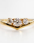 Close-up shot of the gold V-shaped ring showcasing the graduated three-stone diamond setting.