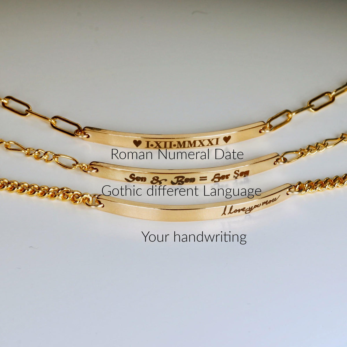 Three gold bar bracelets displaying examples of custom engraving including Roman numerals, gothic text, and handwriting.
