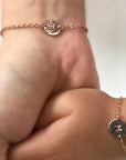 Mother daughter initial bracelet on the wrists.