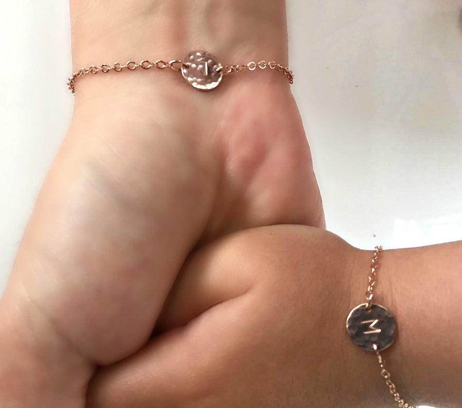 Mother daughter initial bracelet on the wrists.